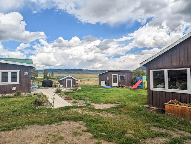 33685 State Highway 134, Toponas, CO 80479 - view of grassy yard featuring a playground, a mountain view, a shed, and a patio