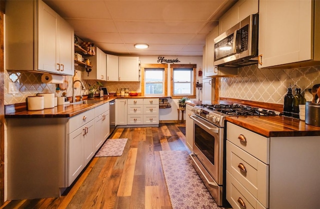 33685 State Highway 134, Toponas, CO 80479 - kitchen featuring butcher block countertops, appliances with stainless steel finishes, open shelves, tasteful backsplash, and dark wood-style flooring