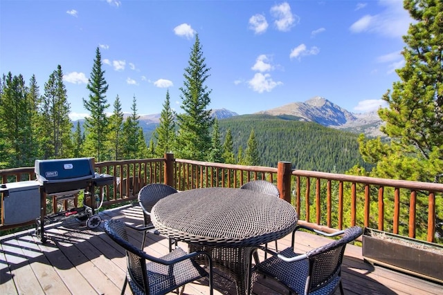 181 Red Fox Ct, Breckenridge, CO 80424 - wooden terrace featuring area for grilling, outdoor dining space, a mountain view, and a wooded view