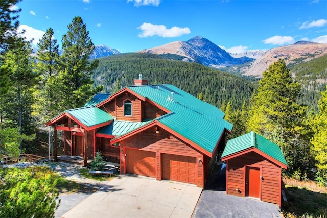 181 Red Fox Ct, Breckenridge, CO 80424 - rustic home featuring a forest view, a chimney, driveway, a mountain view, and a standing seam roof
