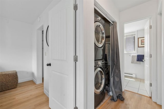 1565 Shadow Run Frontage Unit 103, Steamboat Springs, CO 80487 - laundry area featuring estacked washer and dryer, baseboard heating, light wood-style flooring, and baseboards