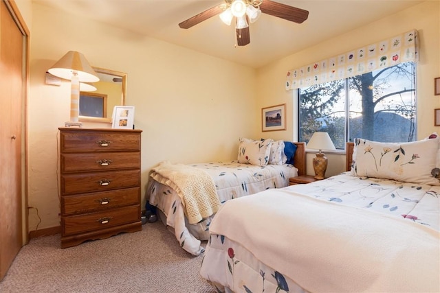 bedroom featuring a ceiling fan, baseboards, a closet, and light colored carpet