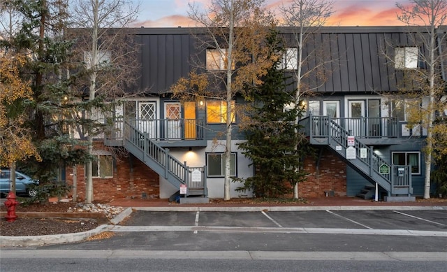 view of building exterior featuring stairs and uncovered parking