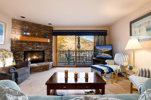 carpeted living room with a stone fireplace