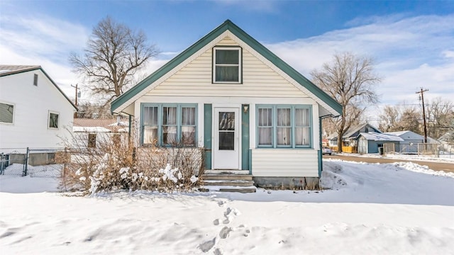bungalow-style home with fence and entry steps