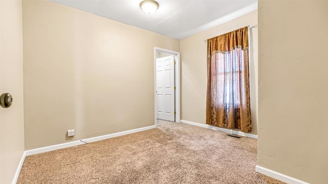 carpeted spare room with visible vents and baseboards