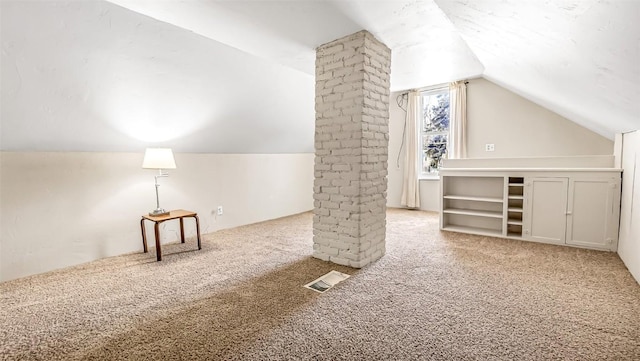 bonus room featuring vaulted ceiling, carpet flooring, visible vents, and decorative columns