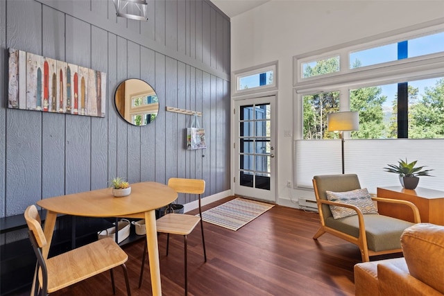 100 N Gold Flake Ter Unit A, Breckenridge, CO 80424 - dining space featuring a towering ceiling, wooden walls, wood finished floors, and a baseboard heating unit