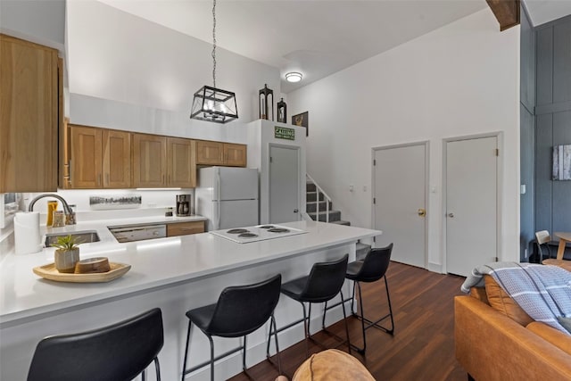 100 N Gold Flake Ter Unit A, Breckenridge, CO 80424 - kitchen with white appliances, a peninsula, brown cabinetry, light countertops, and dark wood-style flooring