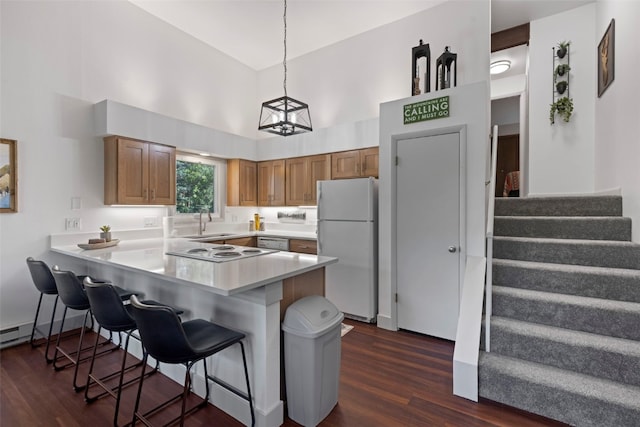 100 N Gold Flake Ter Unit A, Breckenridge, CO 80424 - kitchen featuring white appliances, a peninsula, dark wood finished floors, a breakfast bar, and a high ceiling