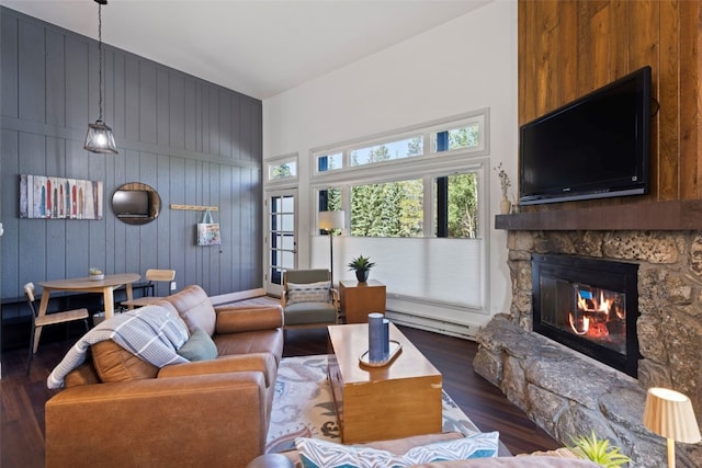 100 N Gold Flake Ter Unit A, Breckenridge, CO 80424 - living area featuring wood finished floors, a baseboard radiator, a stone fireplace, a high ceiling, and wood walls