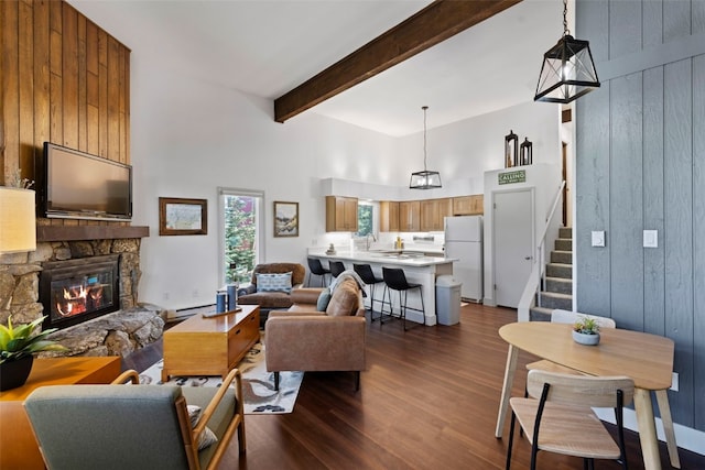 100 N Gold Flake Ter Unit A, Breckenridge, CO 80424 - living area featuring dark wood-style floors, a stone fireplace, beam ceiling, a towering ceiling, and wooden walls