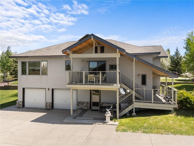 27358 Brandon Cir, Steamboat Springs, CO 80487 - rear view of property featuring stucco siding, a garage, driveway, stone siding, and a shingled roof