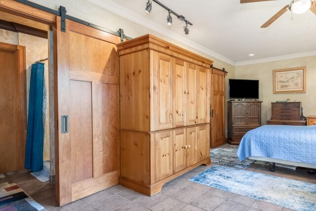27125 Moonlight Way, Steamboat Springs, CO 80487 - bedroom with a barn door, crown molding, ceiling fan, track lighting, and light tile patterned flooring