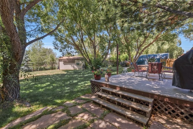 27125 Moonlight Way, Steamboat Springs, CO 80487 - fenced backyard with a wooden deck, an outbuilding, and outdoor dining area