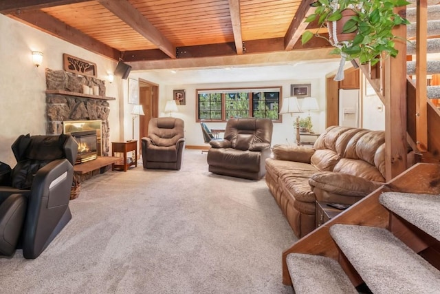 27125 Moonlight Way, Steamboat Springs, CO 80487 - living room with a wood ceiling with exposed beams, a stone fireplace, carpet floors, and stairway