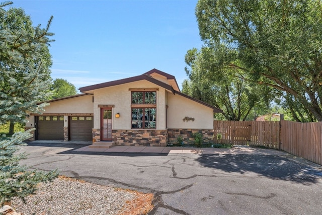 27125 Moonlight Way, Steamboat Springs, CO 80487 - view of front facade featuring stucco siding, a garage, stone siding, and driveway