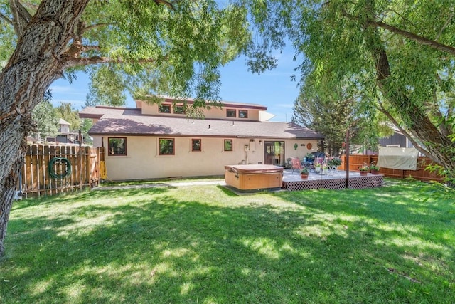 27125 Moonlight Way, Steamboat Springs, CO 80487 - back of property featuring a hot tub, a fenced backyard, and stucco siding