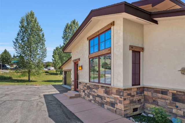 27125 Moonlight Way, Steamboat Springs, CO 80487 - view of side of property featuring stucco siding, driveway, and stone siding