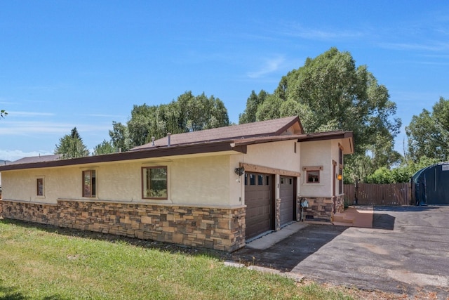 27125 Moonlight Way, Steamboat Springs, CO 80487 - view of side of property with stone siding, stucco siding, a garage, and asphalt driveway