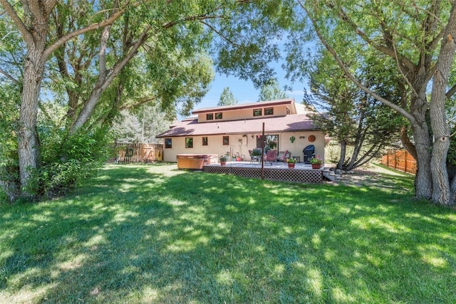 27125 Moonlight Way, Steamboat Springs, CO 80487 - back of property with a hot tub, a wooden deck, a fenced backyard, and stucco siding