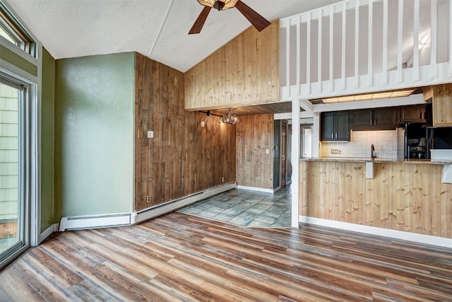7031 Ryan Gulch Rd Unit 301, Silverthorne, CO 80498 - kitchen featuring a baseboard heating unit, black fridge, a ceiling fan, wood finished floors, and a textured ceiling
