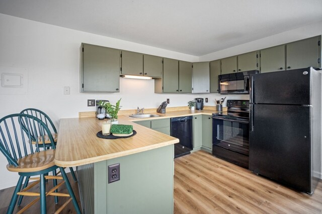 9876 Ryan Gulch Rd Unit 206, Silverthorne, CO 80498 - kitchen featuring black appliances, a peninsula, and green cabinetry