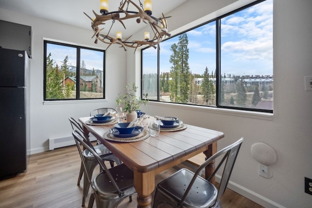9876 Ryan Gulch Rd Unit 206, Silverthorne, CO 80498 - dining space featuring a chandelier, light wood-type flooring, and baseboards