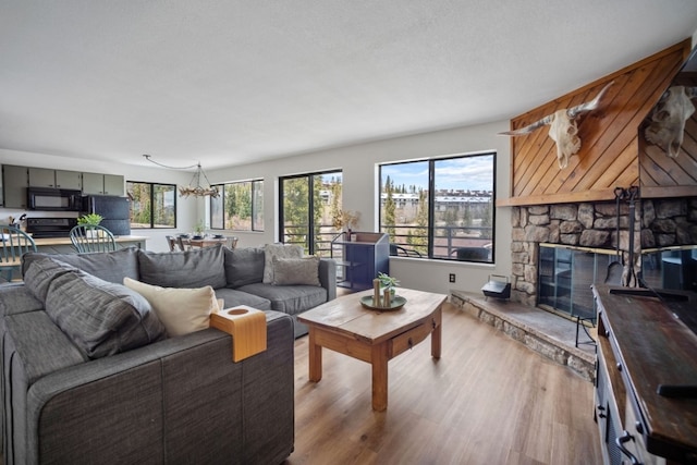 9876 Ryan Gulch Rd Unit 206, Silverthorne, CO 80498 - living room featuring wood finished floors, a fireplace, and a chandelier