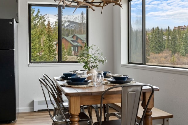 9876 Ryan Gulch Rd Unit 206, Silverthorne, CO 80498 - dining area with wood finished floors, a chandelier, plenty of natural light, and a mountain view