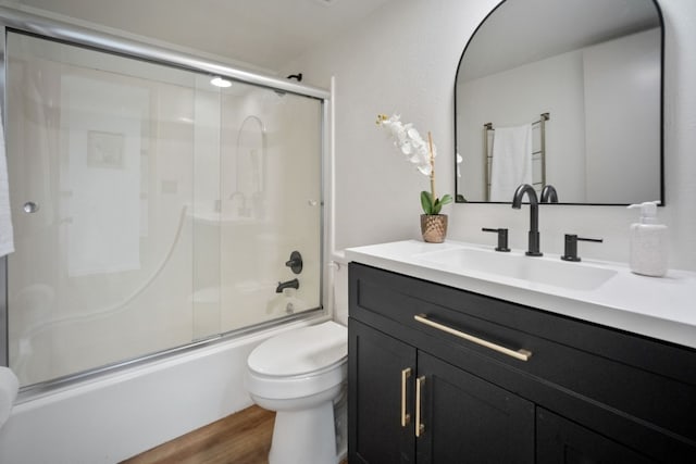 9876 Ryan Gulch Rd Unit 206, Silverthorne, CO 80498 - full bath with toilet, vanity, bath / shower combo with glass door, and wood finished floors