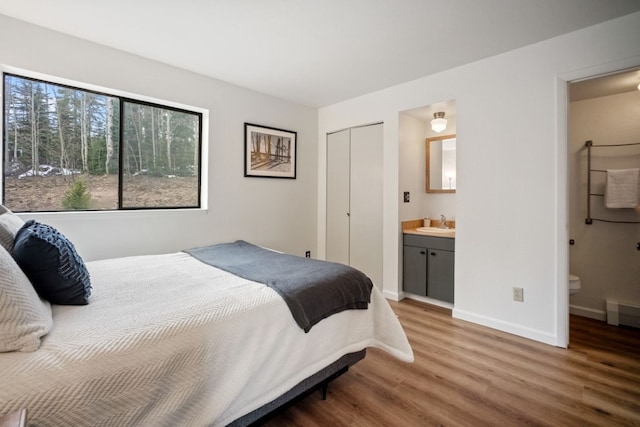 9876 Ryan Gulch Rd Unit 206, Silverthorne, CO 80498 - bedroom with wood finished floors, a sink, baseboards, ensuite bath, and a closet