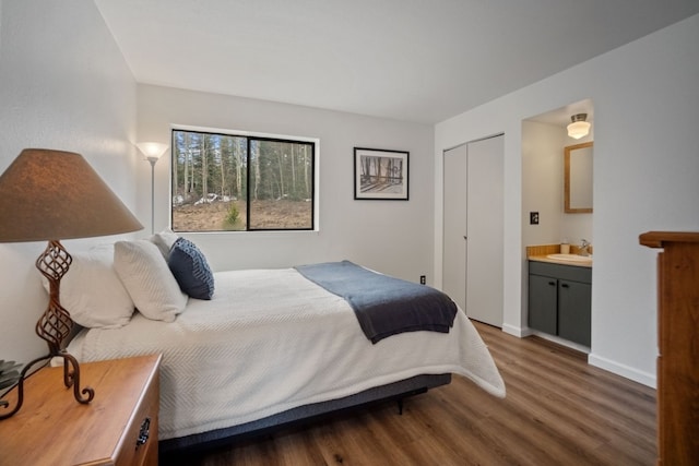 9876 Ryan Gulch Rd Unit 206, Silverthorne, CO 80498 - bedroom featuring wood finished floors, ensuite bathroom, baseboards, a sink, and a closet