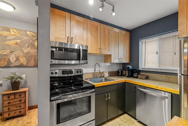 1805 River Queen Ln Unit 205, Steamboat Springs, CO 80487 - kitchen featuring appliances with stainless steel finishes, a sink, light countertops, decorative backsplash, and light brown cabinetry