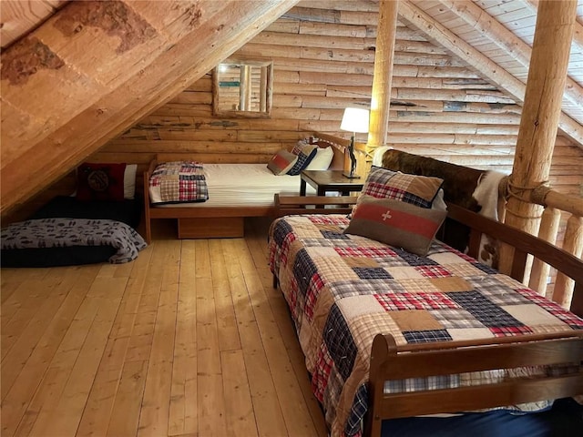 bedroom featuring log walls, hardwood / wood-style flooring, vaulted ceiling, and wood ceiling