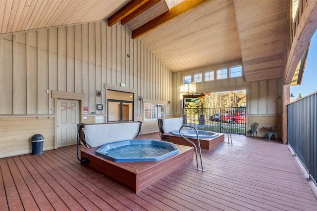 deck featuring fence and hot tub deck surround