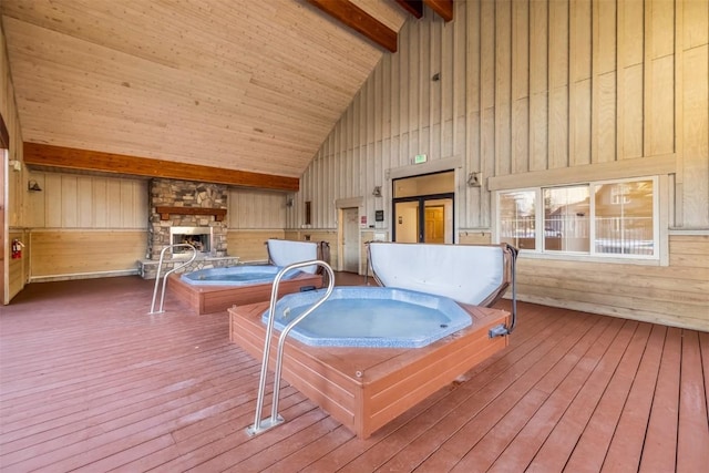 deck with an indoor hot tub and a fireplace