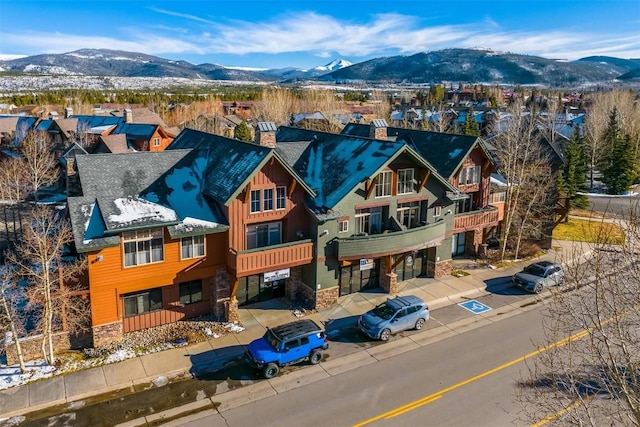 view of front facade with a chimney, a mountain view, and stone siding
