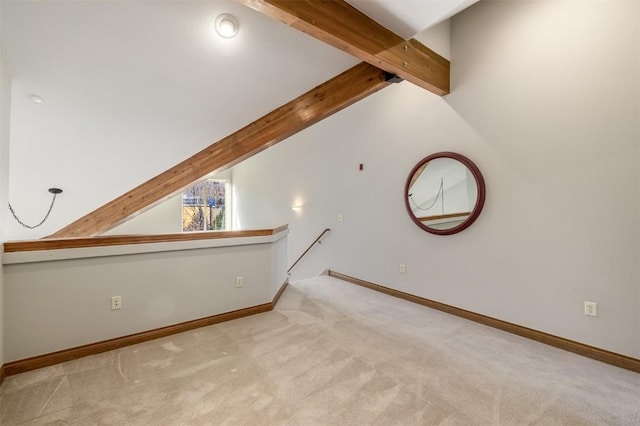 interior space featuring baseboards, vaulted ceiling with beams, and carpet flooring