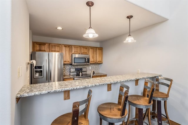 kitchen with light stone counters, tasteful backsplash, hanging light fixtures, stainless steel appliances, and a peninsula