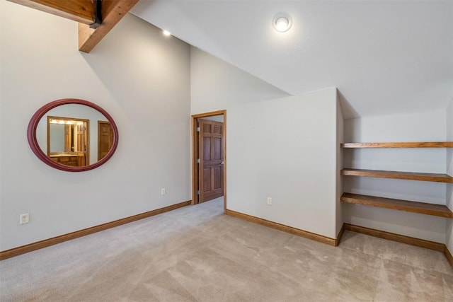 additional living space featuring high vaulted ceiling, carpet floors, and baseboards