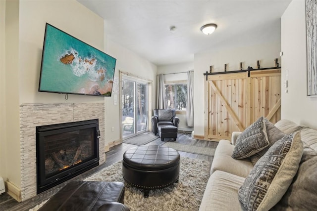 282 Sally Cir, Breckenridge, CO 80424 - living area featuring wood finished floors, a glass covered fireplace, baseboards, and a barn door
