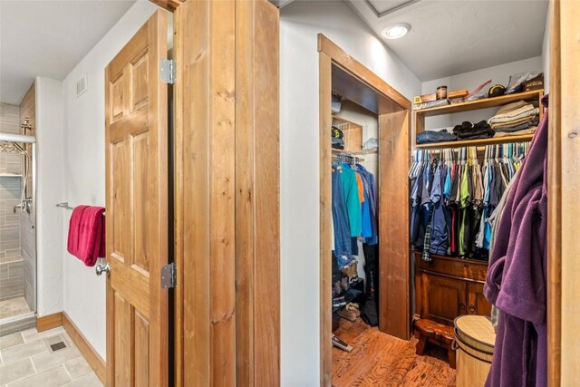 27100 Beaver Canyon Dr, Clark, CO 80428 - bathroom with tiled shower, baseboards, and a walk in closet