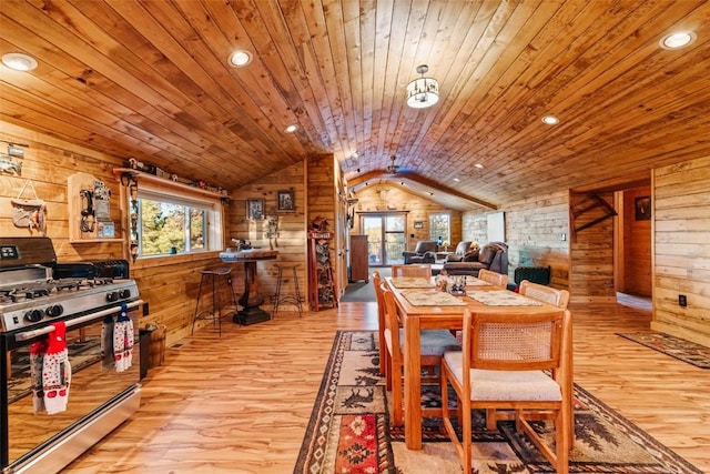 dining area featuring vaulted ceiling, light wood-type flooring, wood ceiling, wood walls, and recessed lighting