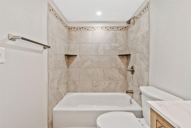bathroom with washtub / shower combination, vanity, and toilet