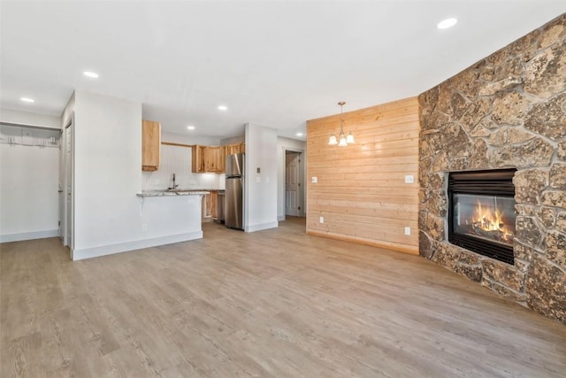 unfurnished living room with light wood-style floors, baseboards, a fireplace, and recessed lighting