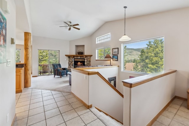129 Lookout Ridge Dr Unit 129, Dillon, CO 80435 - kitchen with light tile patterned floors, lofted ceiling, a stone fireplace, light colored carpet, and ceiling fan