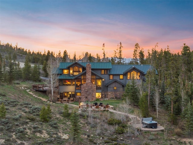 23 Verde Ct, Breckenridge, CO 80424 - back of property at dusk featuring a standing seam roof, metal roof, and stone siding