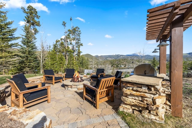 23 Verde Ct, Breckenridge, CO 80424 - view of patio featuring exterior kitchen, an outdoor fire pit, a mountain view, and a pergola