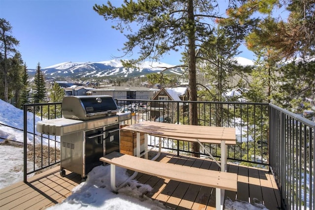 snow covered deck with a mountain view